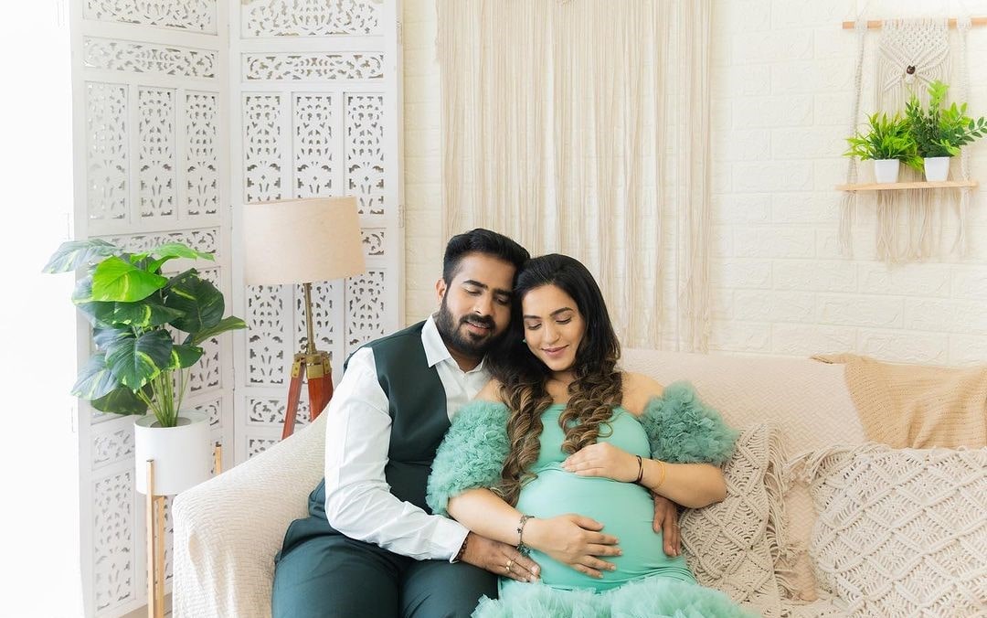 Husband and wife share a magical maternity moment while cuddling their baby bump.